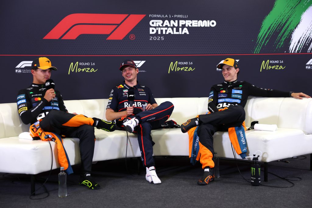 Lando Norris, Max Verstappen and Oscar Piastri sitting together and laughing in a Formula 1 press conference.
